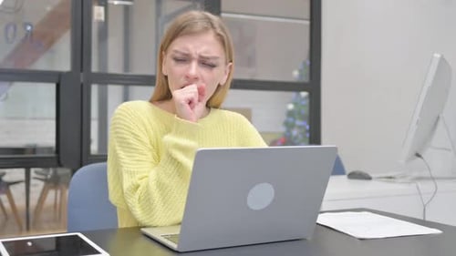Woman Coughing While Working at Laptop in Office