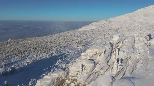 Falaise cornicée et pente dense en épicéas sur la ligne d'horizon de Green Mountain près de Sheregesh