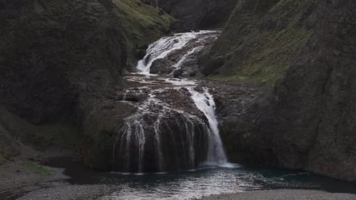 Aerial view of people jumping at Stjornarfoss waterfall, Iceland