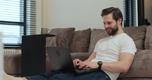 Man Using Laptop While Sitting on Floor