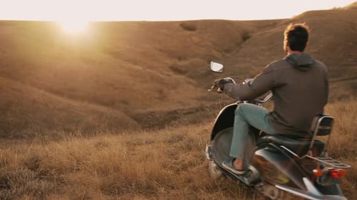 Young Adult Exploring Hills on Scooter at Sunrise