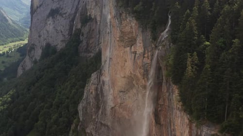 Jib down of stunning waterfall pouring of high mountain