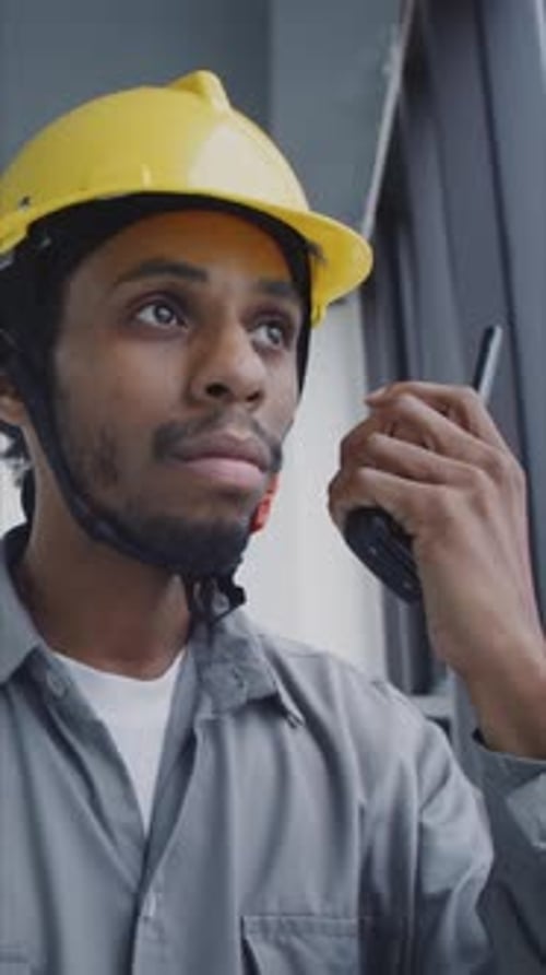 Black Foreman benutzt Walkie-Talkie, um Anweisungen zu geben