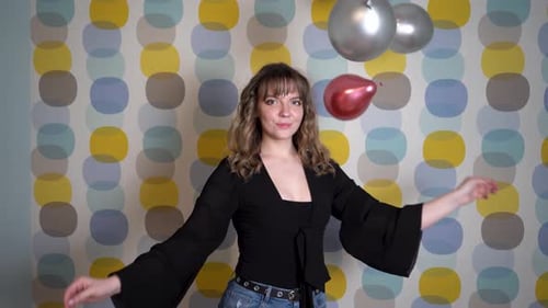 Young Woman Smiling with Balloons in Indoor Setting