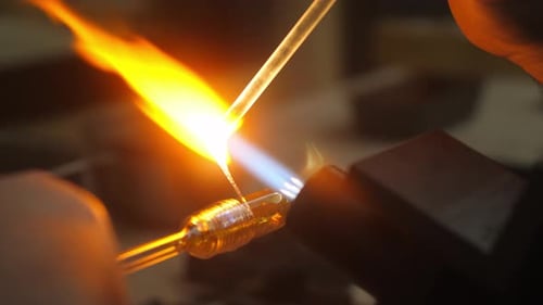 Glass blowing artist melting details in to artwork