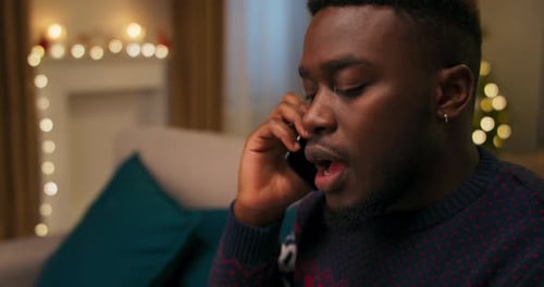 Man in Sweater Talking on Phone During Holiday
