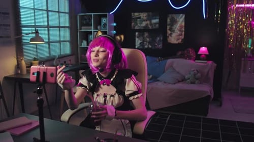 Young Adult Vlogger with Pink Wig at Desk