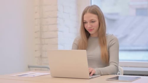 Young Woman Using Laptop in Office