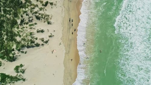 Aerial Over the Sandy Beach with Azure Water and Waves Crashing to the Shore on a Sunny Summer Day