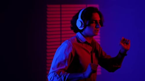 Young Man Listening to Music and Dancing Indoors