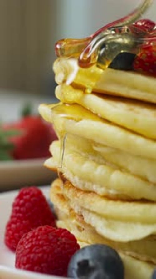 Pouring Syrup on a Stack of Fresh Pancakes