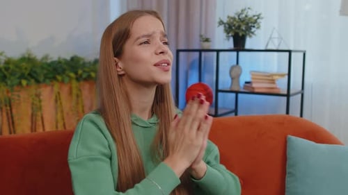 Woman Praying and Clasping Hands Together on Sofa