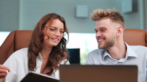 Corporate Fun: Modern Office Discussion Scene with Notebook and Laughter