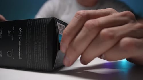 Gros plan recadré d'un homme méconnaissable déchire une casquette en carton de la nouvelle GoPro Hero Black Mini