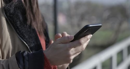 Close up of a young woman with her phone texting and browsing