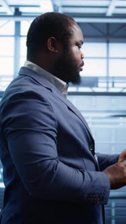 Man Typing in Server Room Working in Tech