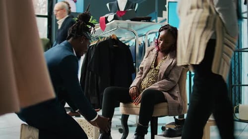 African American Store Employee Helping Woman to Find the Right Shoe Size