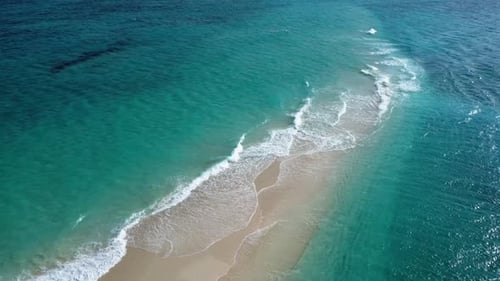 4k drone aerial view of beautiful sandbank surrounded by turquoise ocean waves