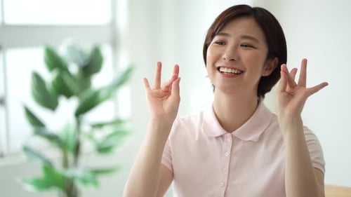 Smiling Woman Waving and Counting with Fingers