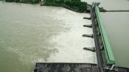 Huge water stream cascade falling down from open gate at hydroelectric water dam