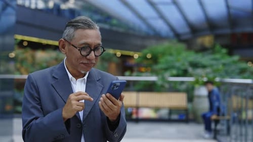 Mature Man Using Cellphone in Urban Environment