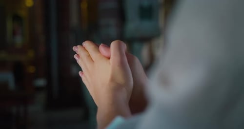 Female Hands in Prayer Inside a Church Closeup