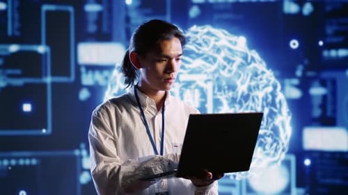 Young Adult Works on Laptop in Futuristic Lab