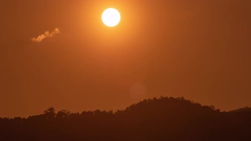 Sonnenuntergang über einem Berg am orangefarbenen Himmel 4k-Zeitraffervideo.