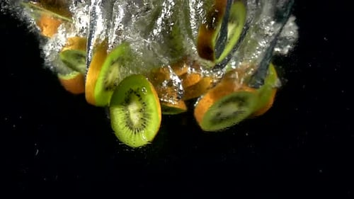 Slices of Kiwi Fruit Falling into Water