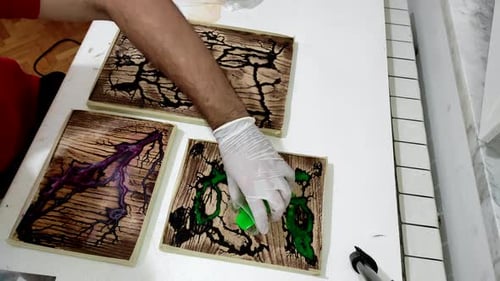 Epoxy resin pouring in the river holes made in the wood. Polyester cutting board made with resin tec