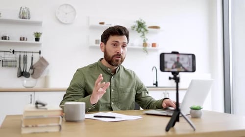 Smartphone Filming Man Working on Laptop at Home Office
