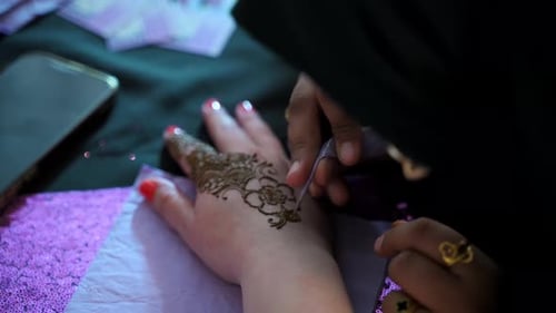 Woman Dressed in Traditional Indian Clothes Painting Henna Tattoo on Woman's Hand Hindu Traditions