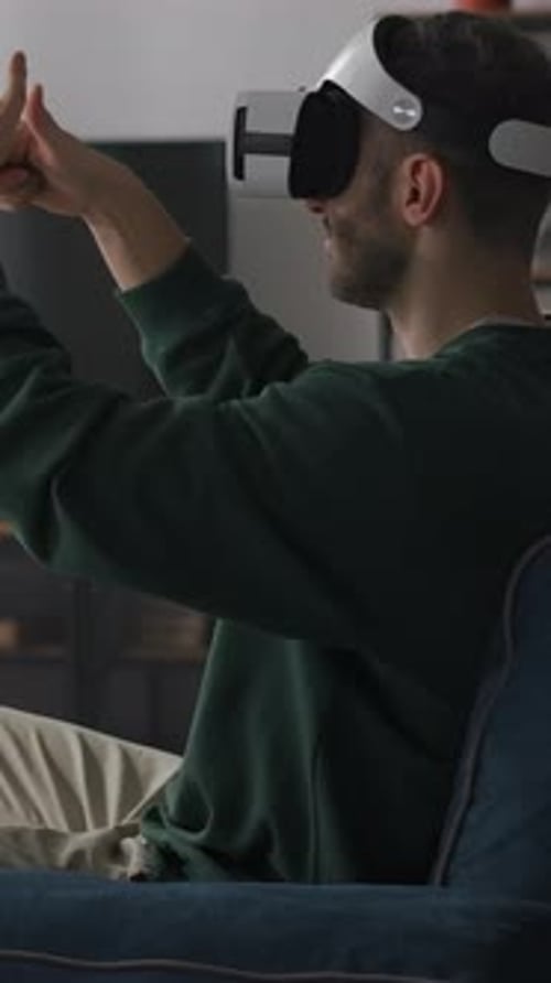 Man Wearing VR Headset at Home on Sofa