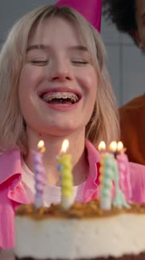 Girl Blowing Out Candles on Birthday Cake