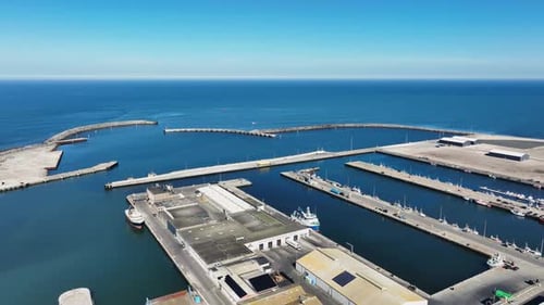 Drohnenblick auf den Port Hanstholm Pier in Dänemark bei Tag, der Küstenaktivitäten zeigt