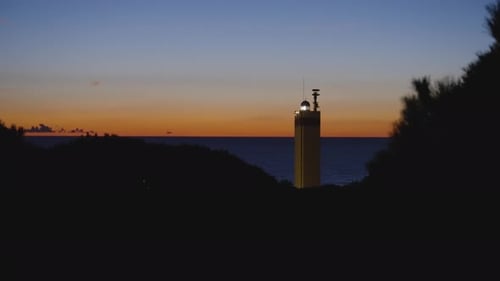 Glowing lighthouse and sunset sky, static view