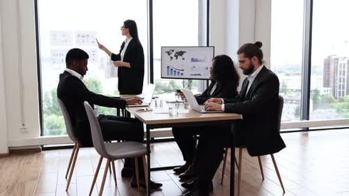 Business Woman Giving Presentation to Diverse Team in Modern Office