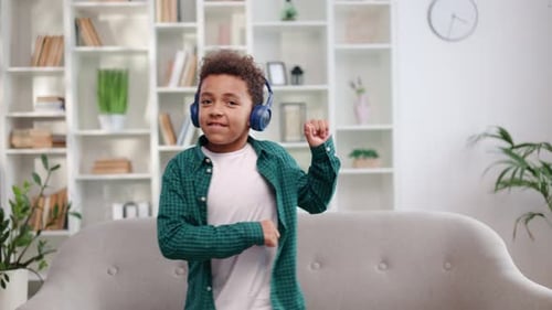 Excited Child Dancing With Headphones In Home