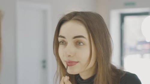 Young Adult Applies Lipstick with Brush