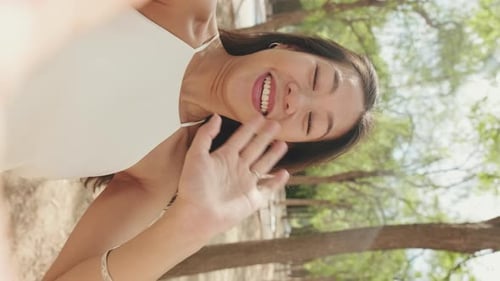 Close-up of smiling young woman making video call from mobile phone while standing in city park