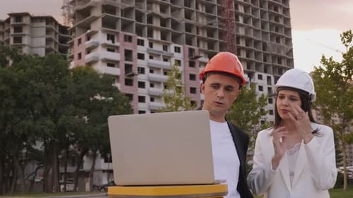 A Young Architect and an Engineer with a Laptop at a Construction Site
