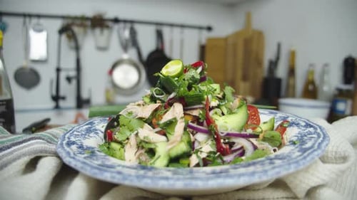 Close up shot of a beautifully plated salad on table in home kitchen. Slow motion shot.