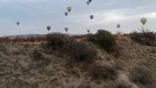 Colorful Hot Air Balloons Flying Over Red Valley at Cappadocia, Turkey At Sunrise - aerial drone sho