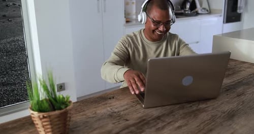 Senior african man enjoying virtual meeting on laptop at home in South Africa