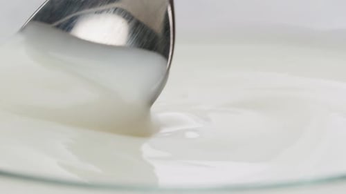White Creamy Sauce Texture Closeup Dip a Spoon Into White Yogurt Macro Dairy Products Concept
