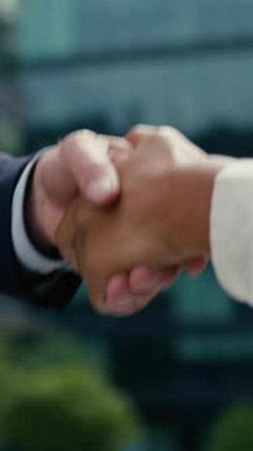 Successful Two Multiethnic Business Colleagues Shaking Hands in City Partnership Cooperation