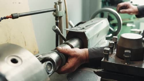 A professional locksmith turner has finished processing the part and takes it out of the clamp mount