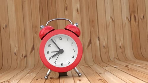 Animation of a caller, bouncing and trembling alarm clock in red on a wooden background.
