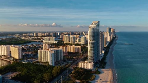Flying closer to the contemporary cityscape of Miami, Florida, USA with lush greenery.