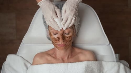 Beautician Removes Facial Mask from Woman in Spa